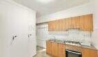 Kitchen with wooden cabinets, built-in oven, double sink and tile backsplash in apartment needing renovation, Playa de Palma