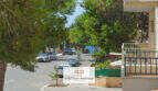 Calle tranquila en Porto Cristo con vistas al mar, pinos e instalación residencial bien cuidada cerca de la playa.