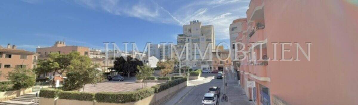 Street view of the apartment in Ses Cadenes, Palma de Mallorca, overlooking a busy street and sunny sky.