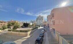 Street view of the apartment in Ses Cadenes, Palma de Mallorca, overlooking a busy street and sunny sky.