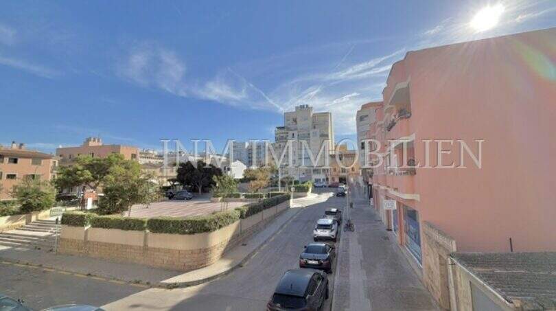 Street view of the apartment in Ses Cadenes, Palma de Mallorca, overlooking a busy street and sunny sky.