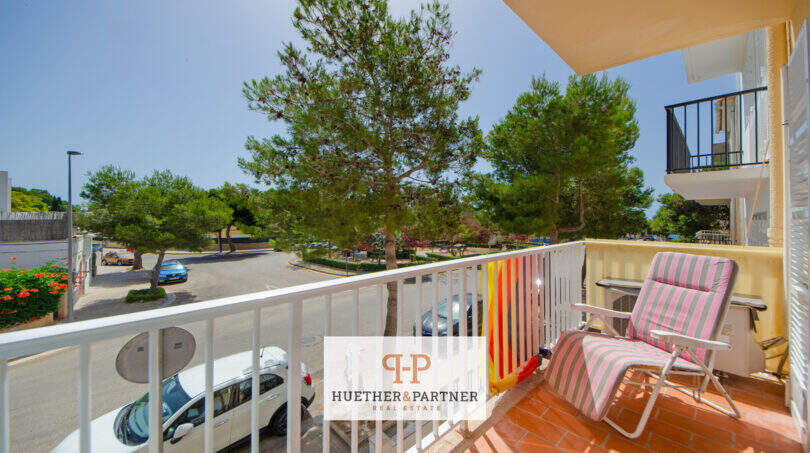 Balcón soleado con tumbonas y vista a pinos y aparcamiento, apartamento Porto Cristo Mallorca