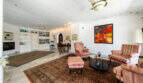 Helles Wohnzimmer der Villa in Cala Murada mit Kamin, Bücherregal, Orientteppich und rosa Sesseln.