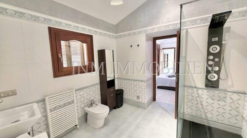 Helles Badezimmer mit Doppelwaschbecken, Bidet, Glasdusche und Heizkörper im Ferienhaus Muro