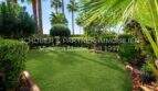 Jardín privado cuidado del apartamento de 4 habitaciones en Cala Millor con césped fresco y palmeras