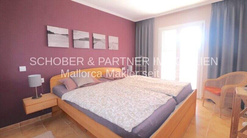 Dormitorio del apartamento de 4 habitaciones en Cala Millor con cama doble, pared de acento lila y acceso a terraza