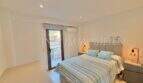 Helles Schlafzimmer mit Doppelbett, blauen Kissen, Klimaanlage und Balkonzugang in Palma-Wohnung