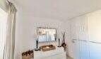 Helles Schlafzimmer mit weißer Kommode, Spiegel und Einbauschrank in Wohnung in Palmanova