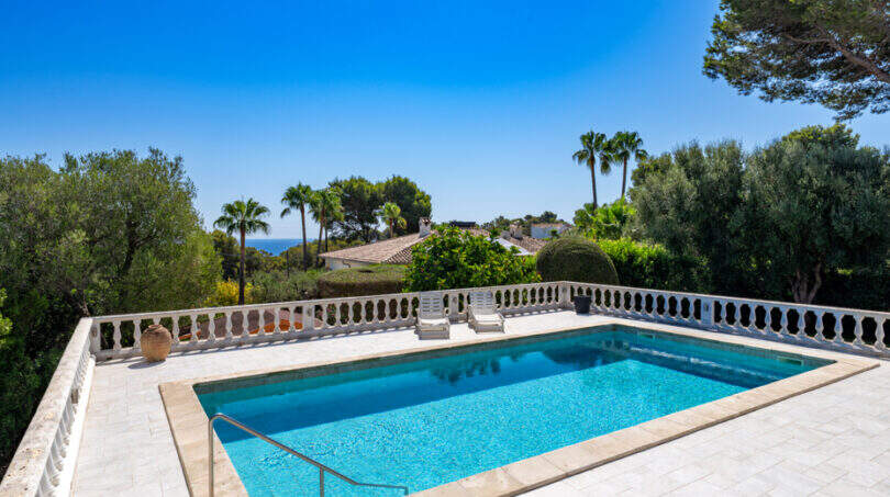 Private pool with white balustrade, sea view and palm trees in Villa Cala Murada