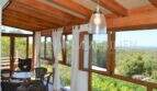 Verglaste Holzterrasse mit Panoramablick über die Landschaft, Hängeleuchte und Sitzgruppe, Landhaus Llucmajor