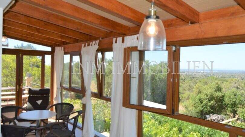 Verglaste Holzterrasse mit Panoramablick über die Landschaft, Hängeleuchte und Sitzgruppe, Landhaus Llucmajor