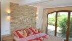 Schlafzimmer mit Steinwand, Doppelbett und Terrassenzugang zum Garten im Landhaus Llucmajor