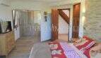 Schlafzimmer mit Doppelbett, Duschkabine, TV und Steinwand im Landhaus Llucmajor