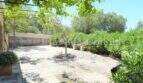 Gepflasterter Innenhof mit Pergola, Bäumen und mediterraner Bepflanzung des Landhauses in Llucmajor