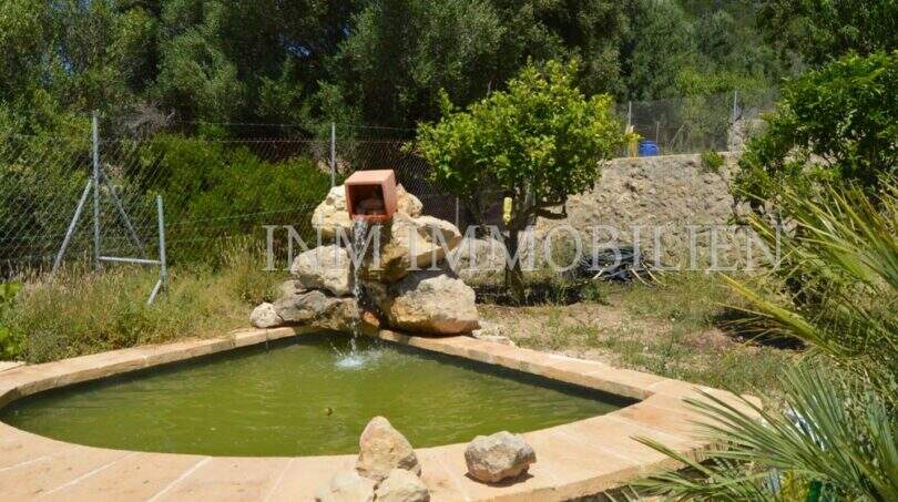 Gartenteich mit Steinbrunnen und üppiger Bepflanzung beim Landhaus in Llucmajor