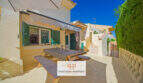 Sonnige Terrasse mit Esstisch, grünen Fensterläden und Markise in Cala Murada