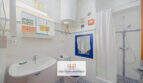 Luminoso baño con ducha, lavabo y ventana en apartamento vacacional cerca de la playa Porto Cristo, Mallorca.