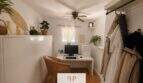 Helles Arbeitszimmer mit weißem Schreibtisch, PC, Korbstuhl, Deckenventilator und Garderobe im Strandhaus Porto Cristo Novo