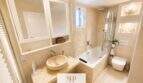 Elegantes Badezimmer mit Naturstein-Waschbecken, Badewanne und Dusche im Ferienhaus nahe Porto Cristo Novo