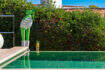 Infinity pool with mirrored water surface and decorative frog sculptures, surrounded by lush hedge at Villa Cala Murada