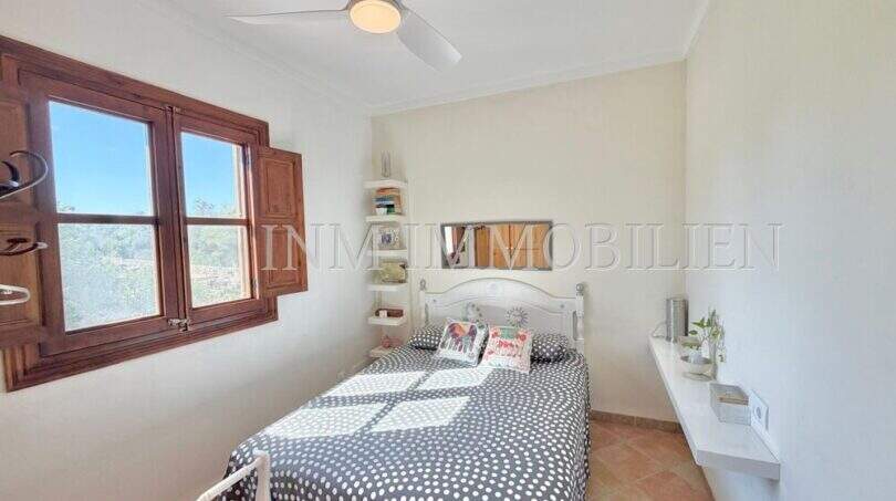 Helles Schlafzimmer der Finca bei Algaida mit Holzfenster, Deckenventilator und mediterranem Flair.