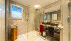 Modern bathroom of the sea view villa in Cala Murada with walk-in shower, natural stone washbasin and pebble flooring