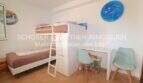 Kinderzimmer der Wohnung in Sa Coma mit Etagenbett, Schreibtisch und Stühlen in hellen Farben