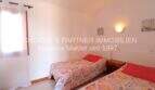 Bright bedroom with two single beds and wall lamp in finca with sea view in Son Carrió.