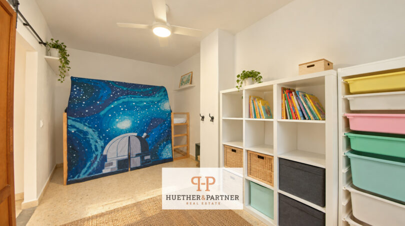 Kinderzimmer mit Weltraum-Spielzelt, weißem Kallax-Regal, bunten Aufbewahrungsboxen und Deckenventilator in Manacor
