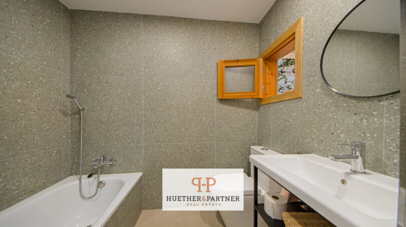Modernes Badezimmer mit Terrazzo-Fliesen, Einbaubadewanne, Doppelwaschbecken und Holzfenster im Stadthaus Manacor