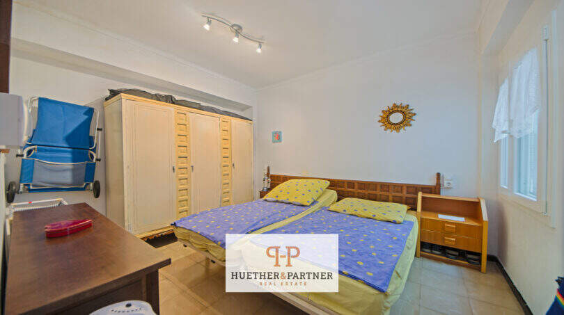 Dormitorio del apartamento vacacional Porto Cristo con cama doble, armario de madera y spots de techo
