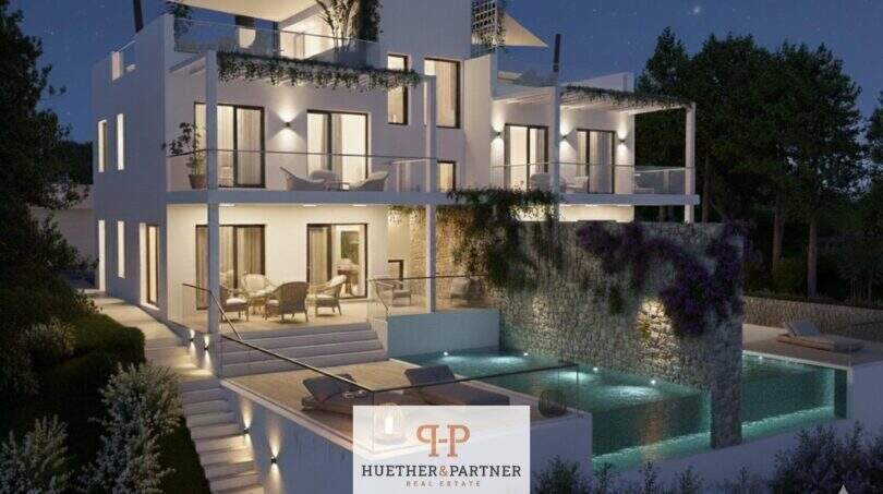 Moderne Doppelhaushälfte Cala d'Or bei Nacht mit beleuchtetem Privatpool und mehreren Terrassen