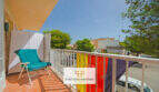 Balcón soleado cerca de vistas al mar, protección solar multicolor y silla, apartamento Porto Cristo Mallorca