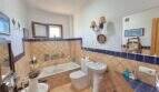 Mediterran gefliestes Badezimmer mit Badewanne, Waschbecken und WC in mediterraner Finca bei Algaida