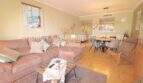 Luminosa sala de estar con sofá, mesa de centro y comedor abierto en un apartamento de 4 habitaciones en Cala Millor