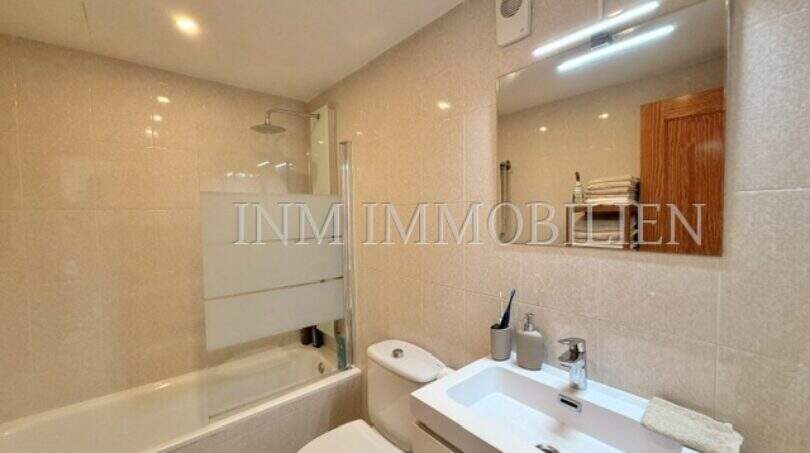 Helles Badezimmer mit Badewanne, Dusche, WC und modernem Waschtisch in Wohnung in Palmanova
