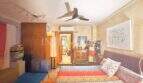 Schlafzimmer der Wohnung in Palma mit bunter Tagesdecke, Holzschrank, Deckenventilator und Klimaanlage.