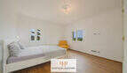 Helles Schlafzimmer der Finca Santa Maria mit Holzboden, Doppelbett und Tramuntana-Blick aus den Fenstern.