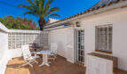Sonnige Terrasse mit weißen Gartenmöbeln, Zierblöcken-Trennwand und Palme der Villa in Cala Murada