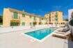 Complejo de nueva construcción en Cala Millor con piscina comunitaria, tumbonas y fachada mediterránea, a aprox. 200 m de la playa.