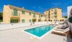 Complejo de nueva construcción en Cala Millor con piscina comunitaria, tumbonas y fachada mediterránea, a aprox. 200 m de la playa.