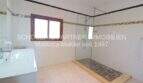 Bright bathroom of the Mallorca finca with glass shower, sink and decorative wall tiles.