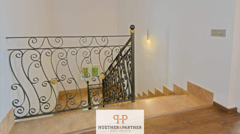 Elegantes Treppenhaus der Finca Santa Maria mit schmiedeeisernem Geländer und Natursteintreppe