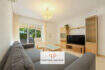 Helles Wohnzimmer der Erdgeschosswohnung Cala Antena mit Sofas, TV-Möbel und Zugang zur Terrasse.