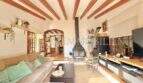 Salón luminoso con techo de vigas de madera, chimenea y encanto mediterráneo en Sa Ràpita