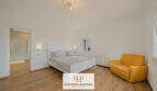 Helles Schlafzimmer der Finca Santa Maria mit Doppelbett, Laminatboden, En-suite-Bad und gelbem Sessel.