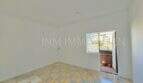 Empty bright bedroom with tile floor and balcony door with outdoor area in apartment needing renovation, Playa de Palma