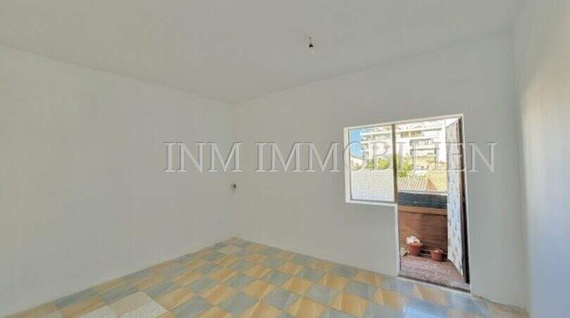 Empty bright bedroom with tile floor and balcony door with outdoor area in apartment needing renovation, Playa de Palma