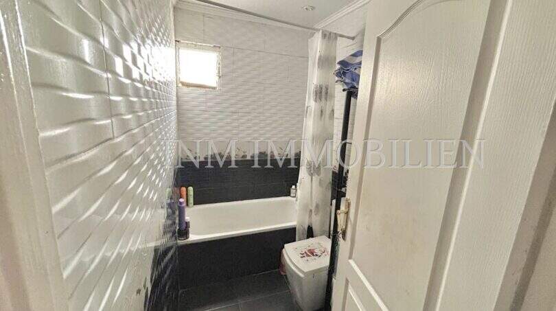 Badezimmer mit Badewanne, WC, schwarz-weißen Fliesen und Fenster in Wohnung in El Arenal, Palma de Mallorca