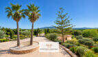 Finca Santa Maria: Gepflasterte Einfahrt mit Palmen, mediterranem Garten und Blick auf die Tramuntana-Berge.